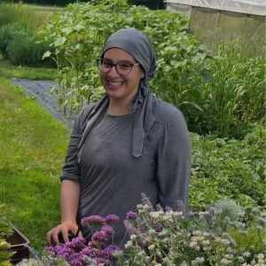 Amira Shatara poses for a photo in a flower garden.